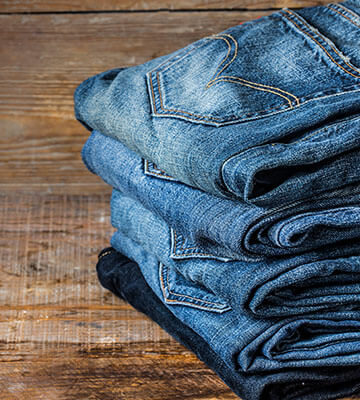 Five folded blue jeans